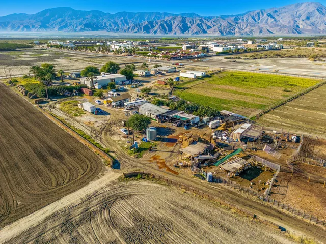 an aerial view of ocean and residential houses with outdoor space