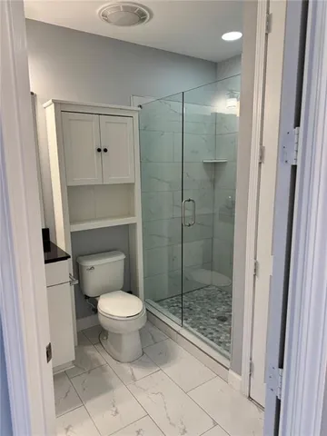 a bathroom with a toilet and a shower