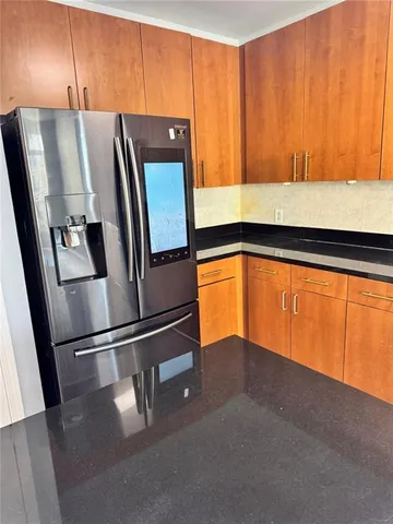 a kitchen with metallic refrigerator and window