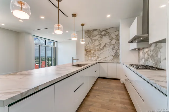 a kitchen with stainless steel appliances a stove a sink island and a refrigerator