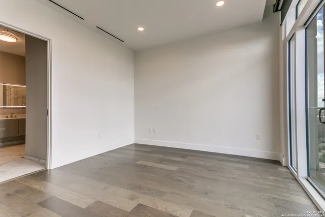 an empty room with wooden floor & closet area