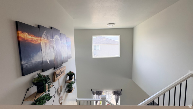 7889 Bristlecone Road Eagle Mountain, UT 84005 - Photo 19 of 42 Stairwell featuring a square window, white walls, and a white railing with black balusters