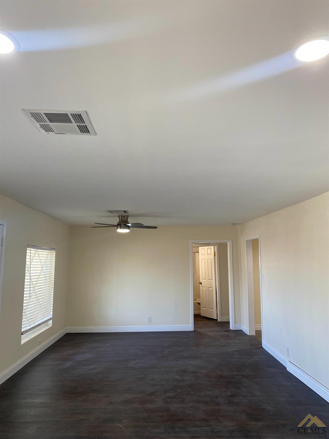 Undisclosed Address Taft, CA 93268 - Photo 12 of 22 an empty room with wooden floor and windows