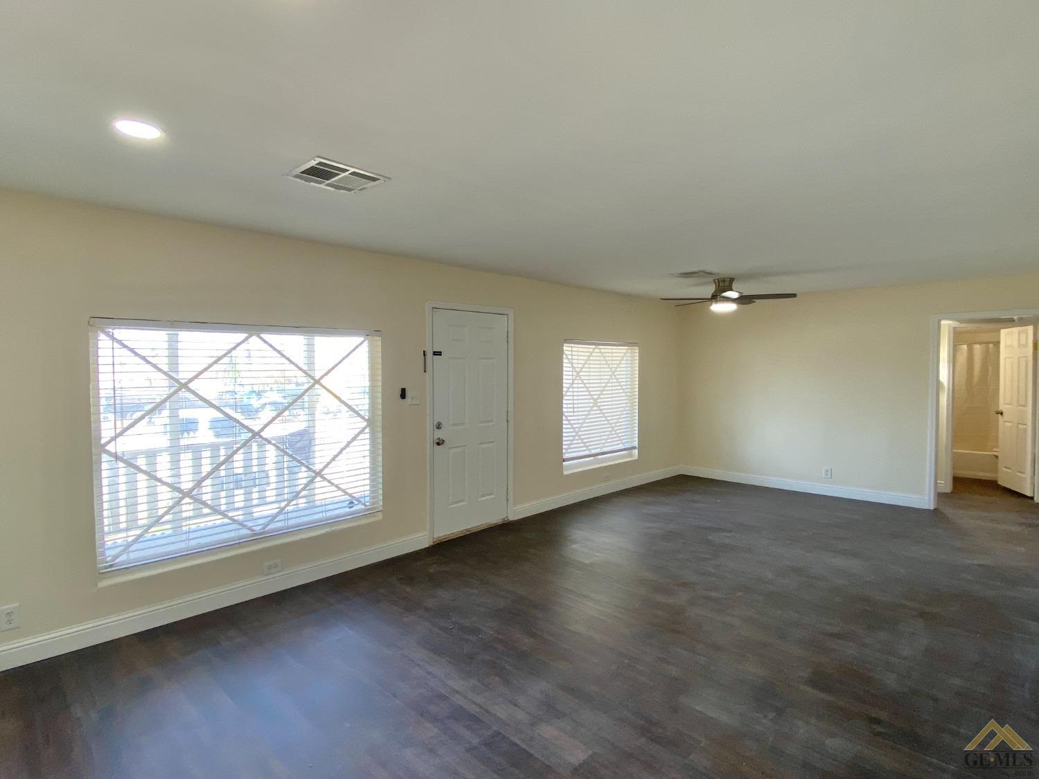 Undisclosed Address Taft, CA 93268 - Photo 14 of 22 an empty room with wooden floor and windows