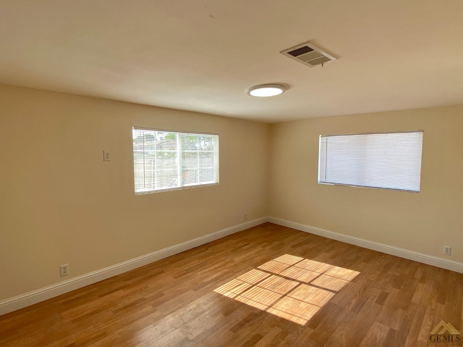 Undisclosed Address Taft, CA 93268 - Photo 16 of 22 a view of an empty room with wooden floor and a window