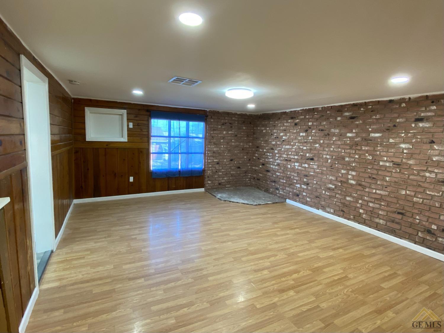 Undisclosed Address Taft, CA 93268 - Photo 3 of 22 an empty room with wooden floor and windows