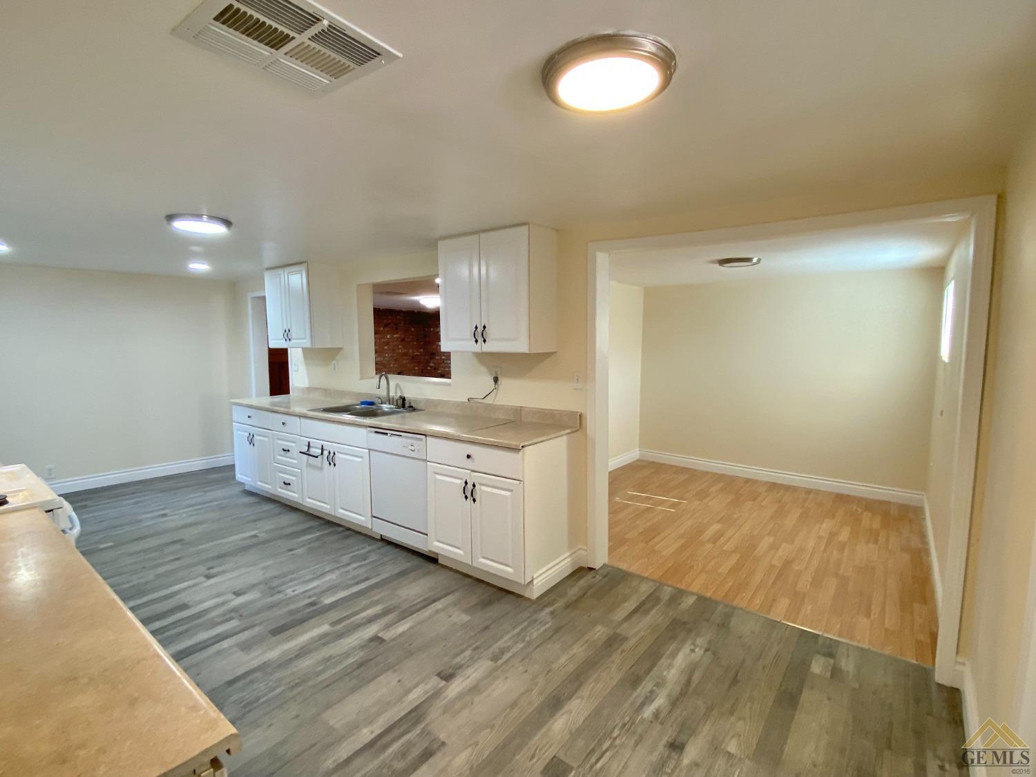 Undisclosed Address Taft, CA 93268 - Photo 8 of 22 a large kitchen with a stove wooden floor and a sink