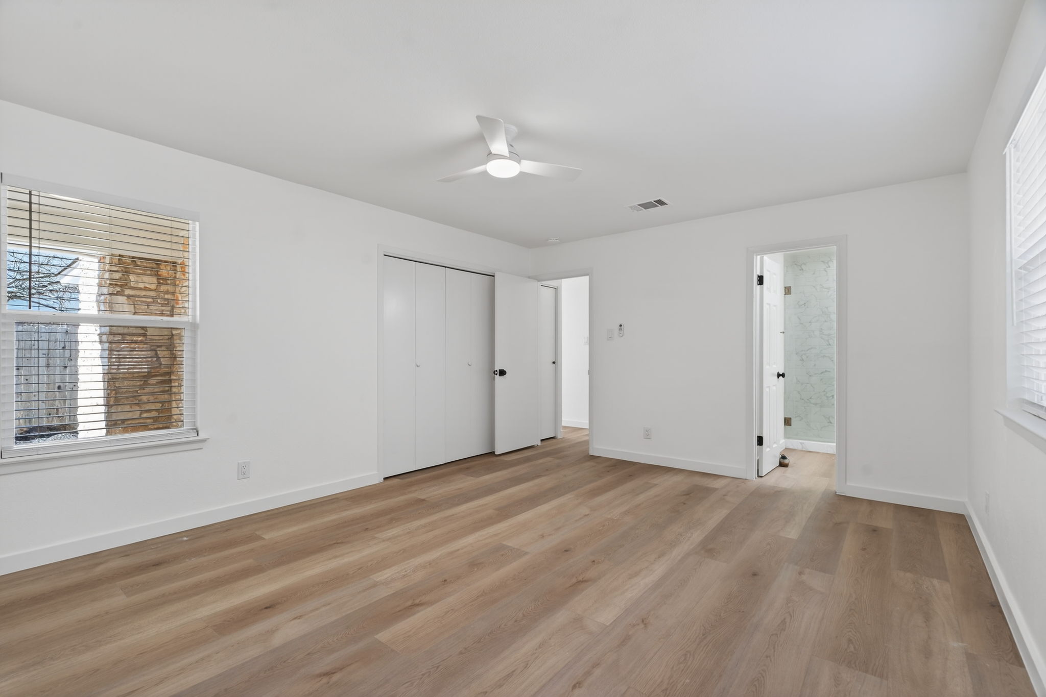 8400 Seminary Ridge Drive Austin, TX 78745 - Photo 23 of 37 Unfurnished bedroom featuring light wood-style floors, a ceiling fan, a closet, and connected bathroom