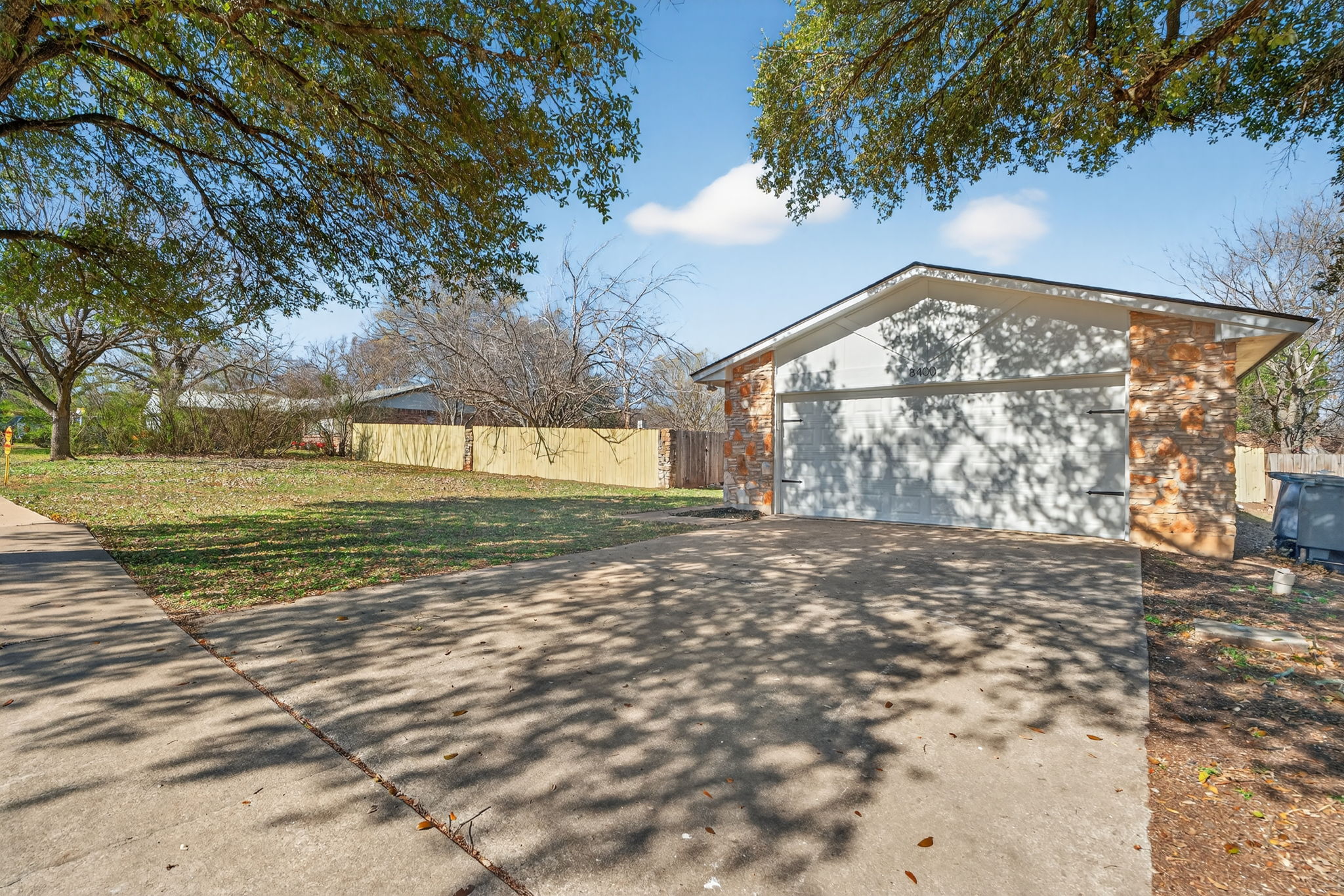 8400 Seminary Ridge Drive Austin, TX 78745 - Photo 3 of 37 View of property exterior with driveway, stone siding, and a garage