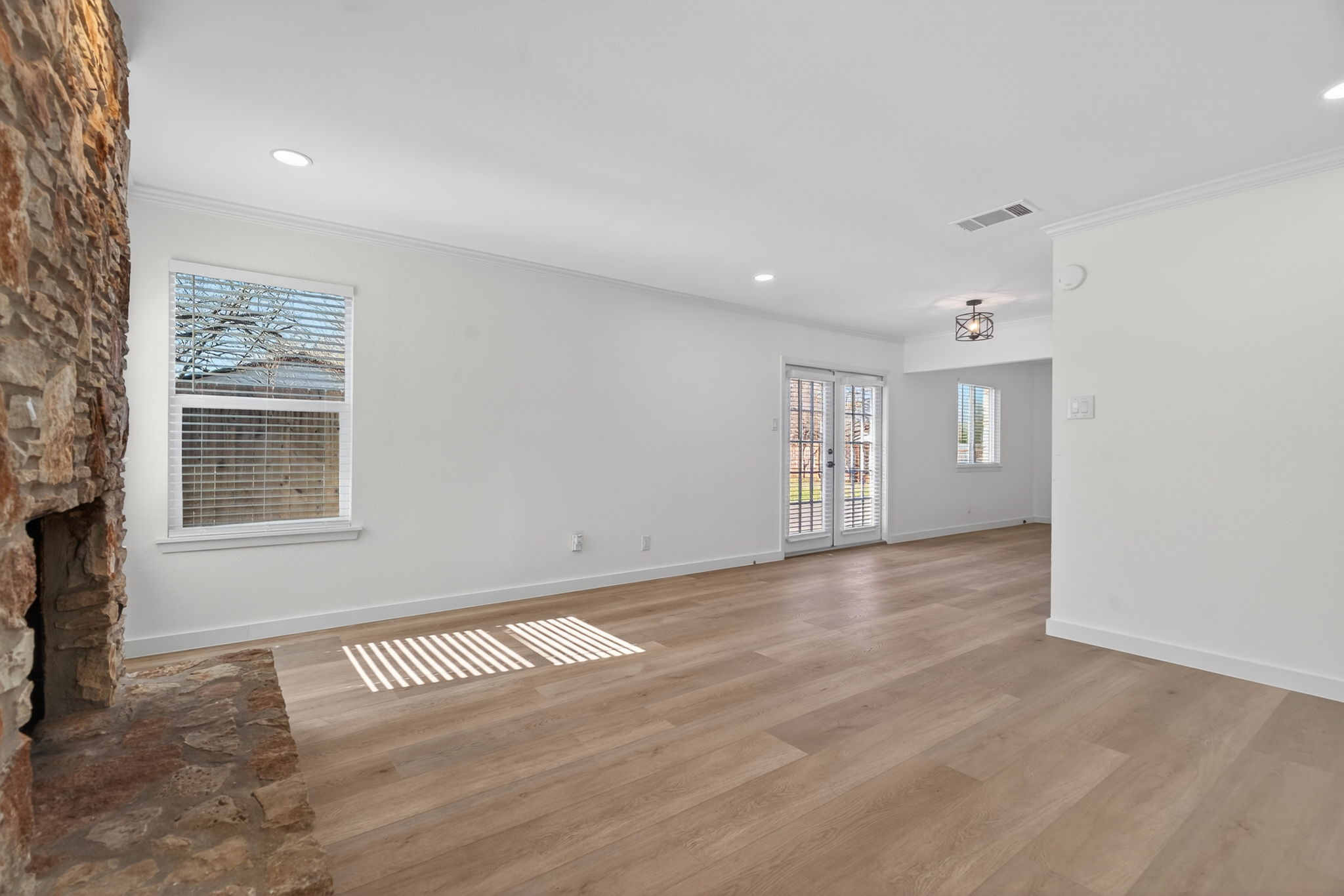 8400 Seminary Ridge Drive Austin, TX 78745 - Photo 5 of 37 Unfurnished living room with ornamental molding, light wood-type flooring, a fireplace, and recessed lighting