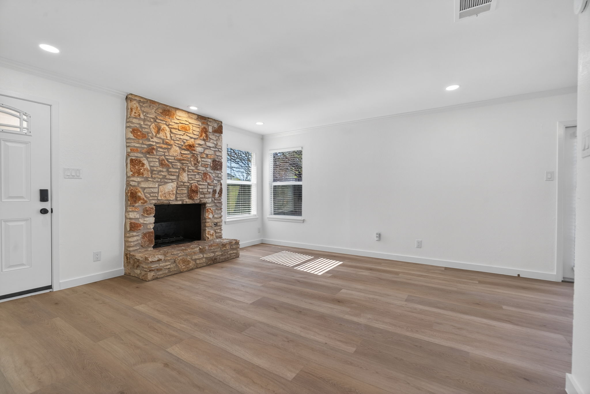 8400 Seminary Ridge Drive Austin, TX 78745 - Photo 6 of 37 Unfurnished living room with a fireplace, light wood-style flooring, ornamental molding, and recessed lighting