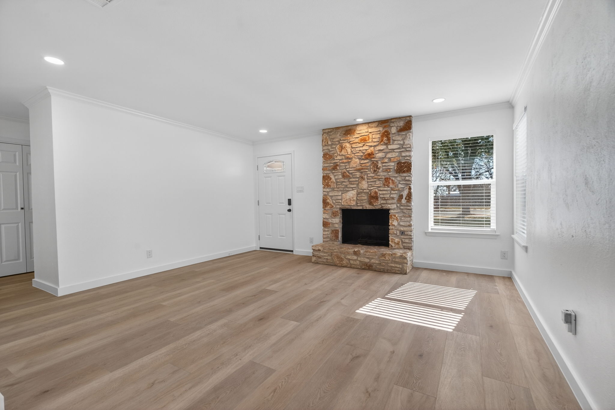 8400 Seminary Ridge Drive Austin, TX 78745 - Photo 8 of 37 Unfurnished living room featuring ornamental molding, light wood-style floors, and a fireplace