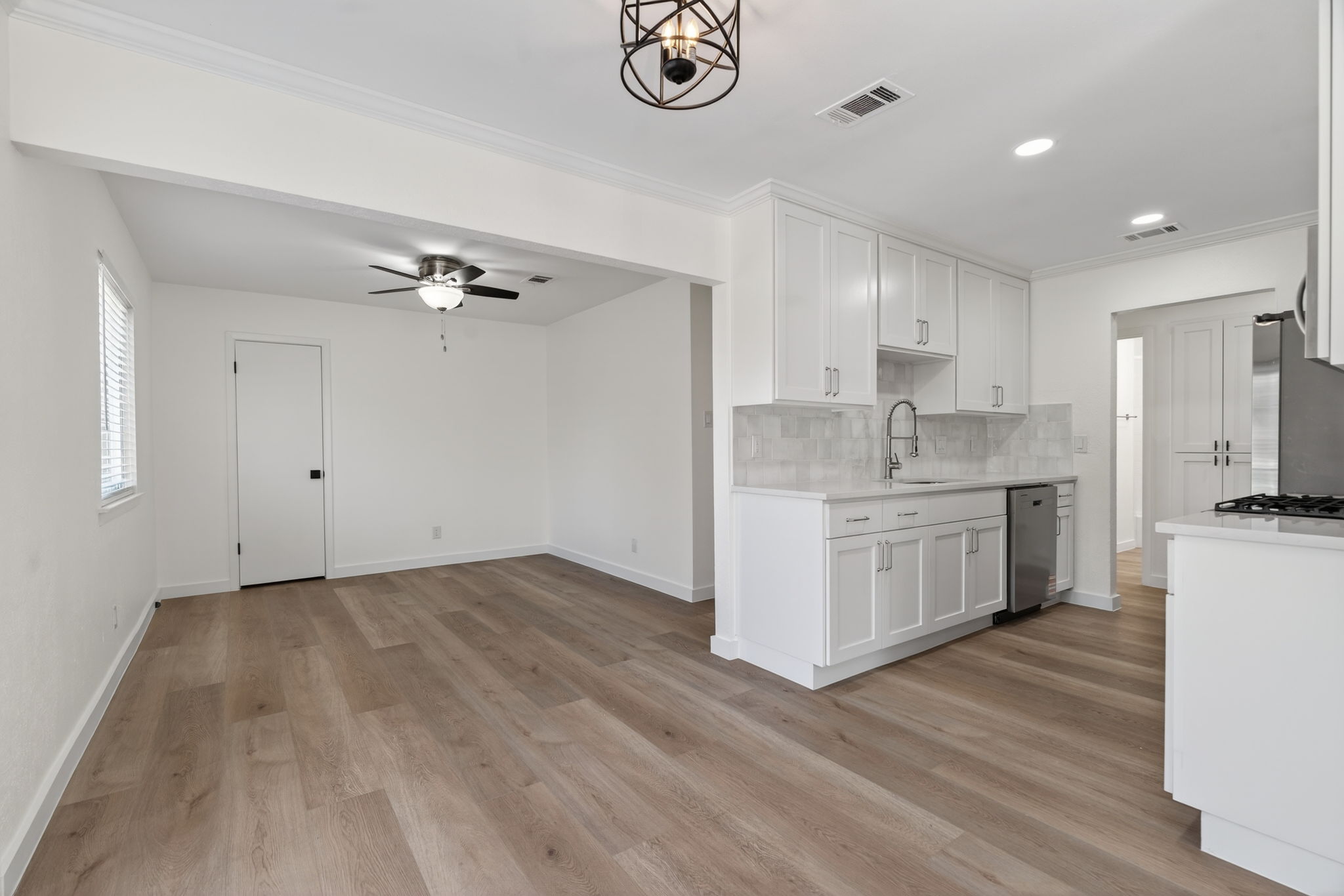 8400 Seminary Ridge Drive Austin, TX 78745 - Photo 10 of 37 Kitchen with white cabinets, tasteful backsplash, crown molding, stainless steel appliances, and ceiling fan