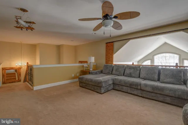 a living room with furniture and a ceiling fan