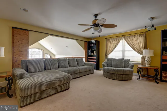 a living room with furniture a ceiling fan and a window