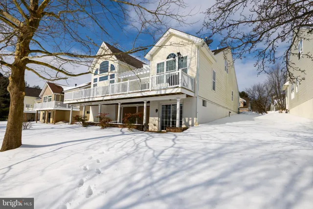 a view of a white house with a large trees
