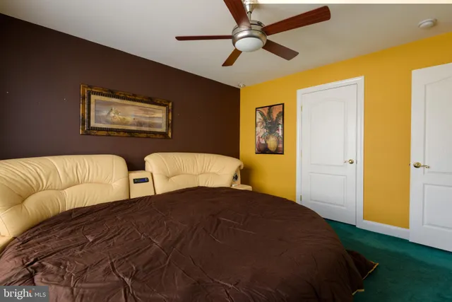 a bedroom with two beds and a ceiling fan