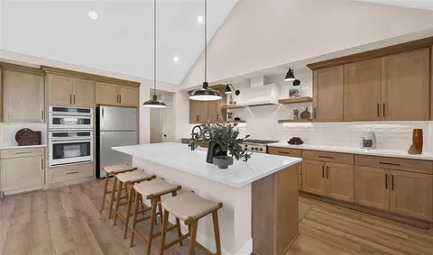 a kitchen with stainless steel appliances granite countertop a stove and a refrigerator