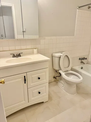 a bathroom with a toilet a sink and mirror