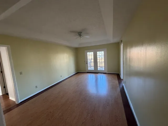 an empty room with wooden floor and windows