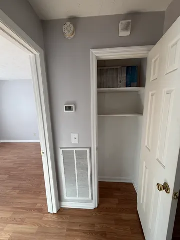 a view of a hallway with wooden floor and staircase