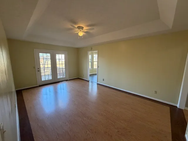 an empty room with wooden floor and windows