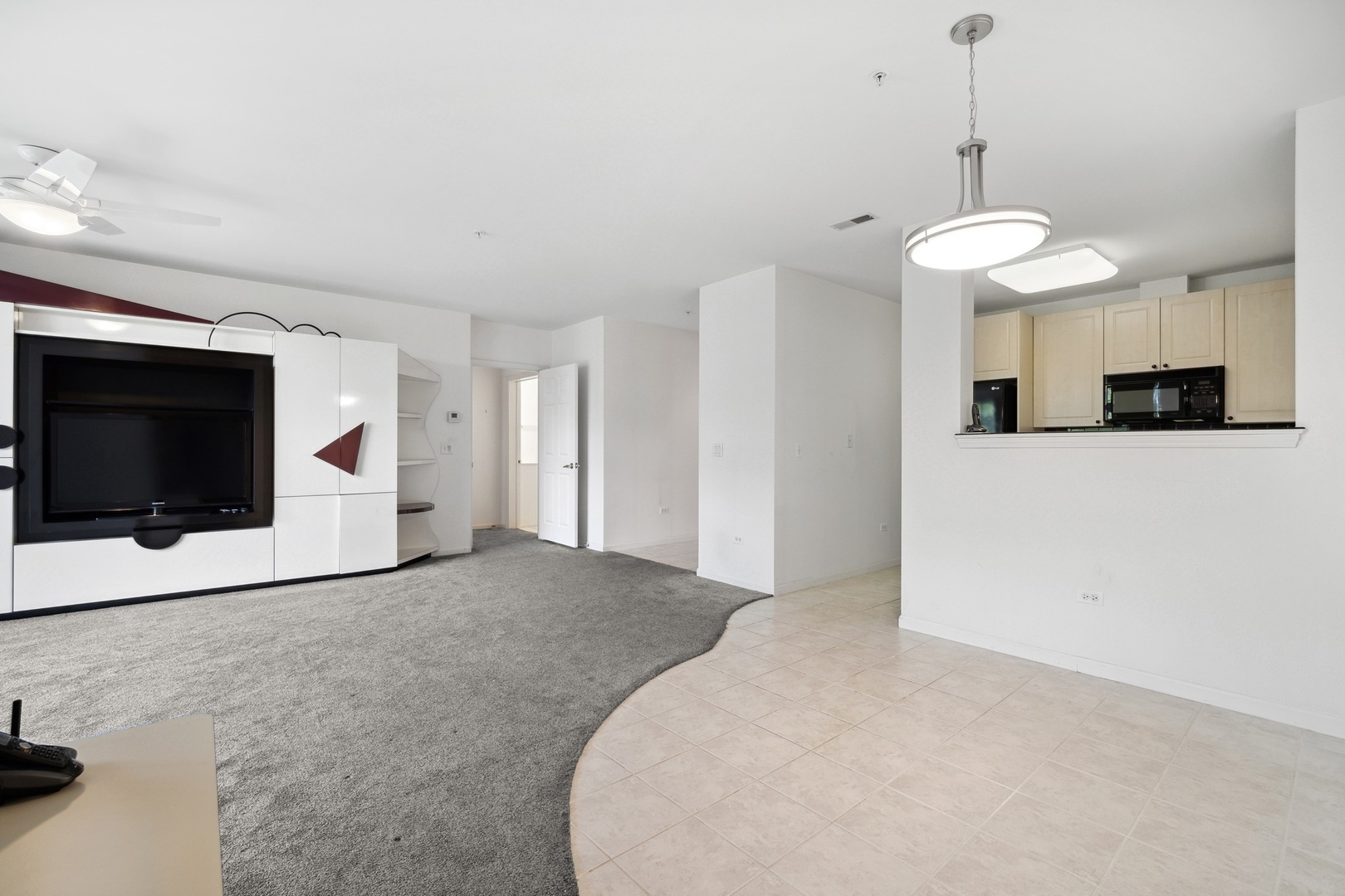 820 Weidner Road, Unit 304 Buffalo Grove, IL 60089 - Photo 7 of 18 a view of a livingroom with a chandelier fan and kitchen