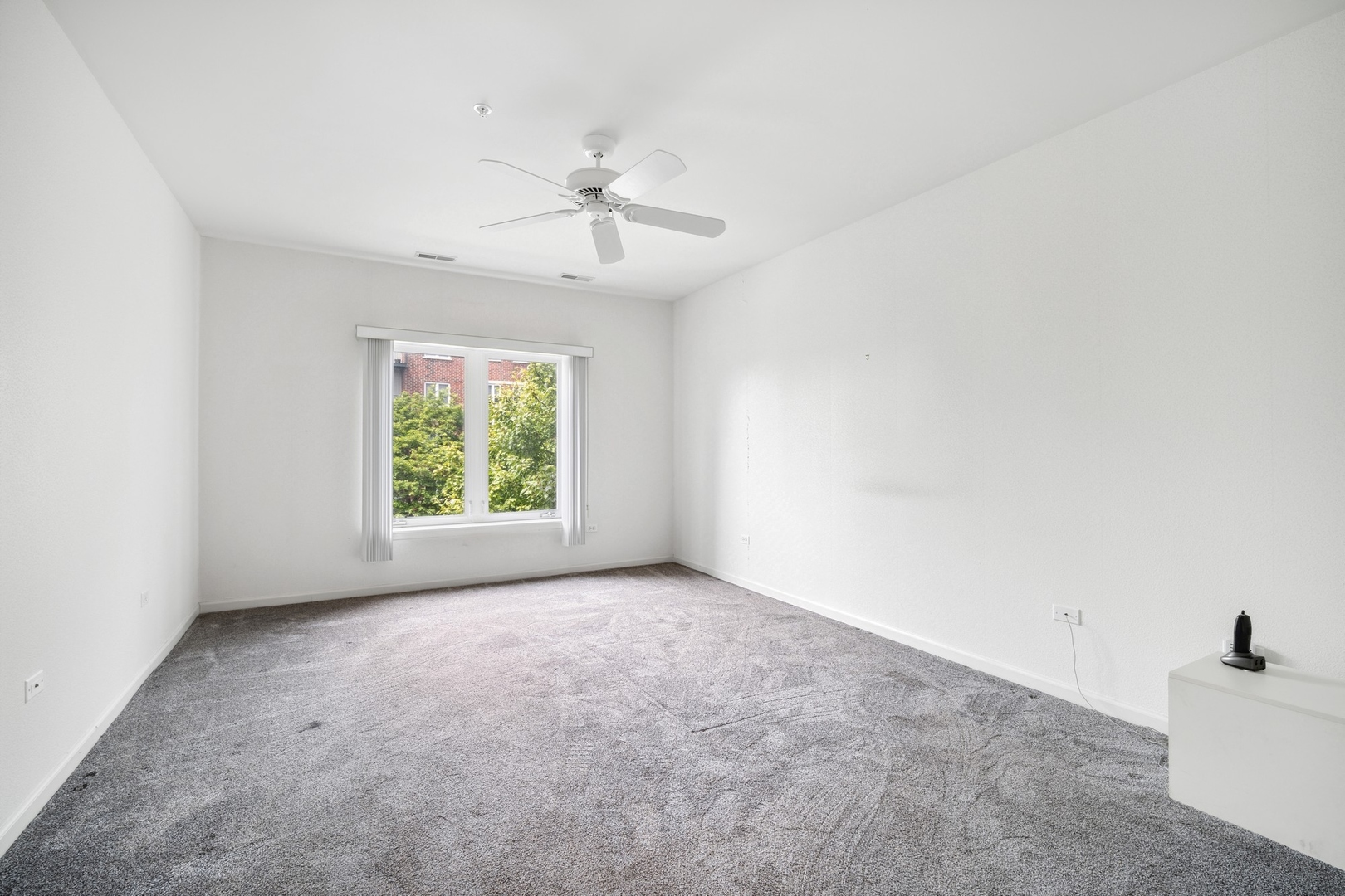 820 Weidner Road, Unit 304 Buffalo Grove, IL 60089 - Photo 10 of 18 an empty room with windows and fan