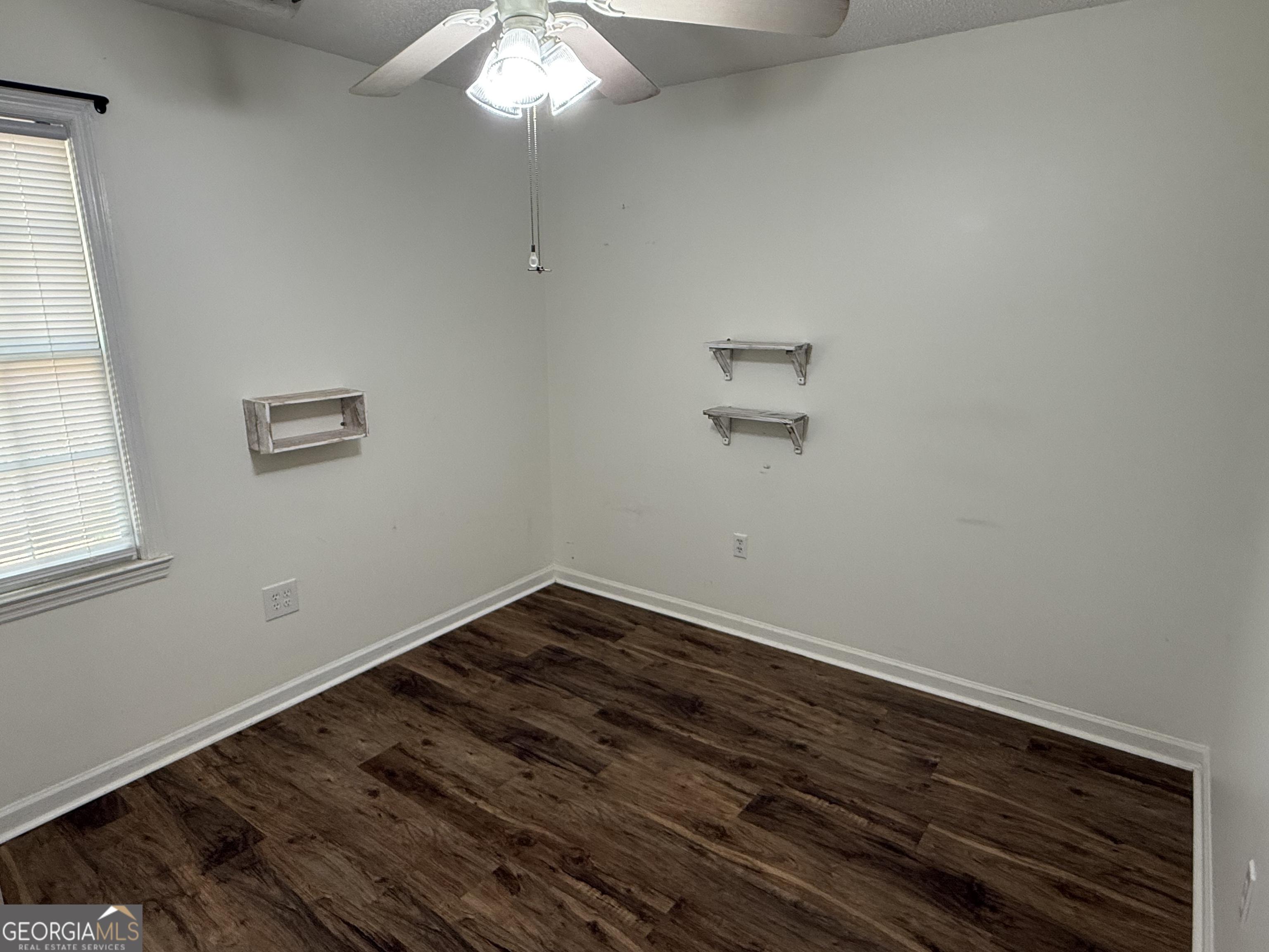 109 Layla Court Athens, GA 30605 - Photo 23 of 32 an empty room with a chandelier fan and wooden floor