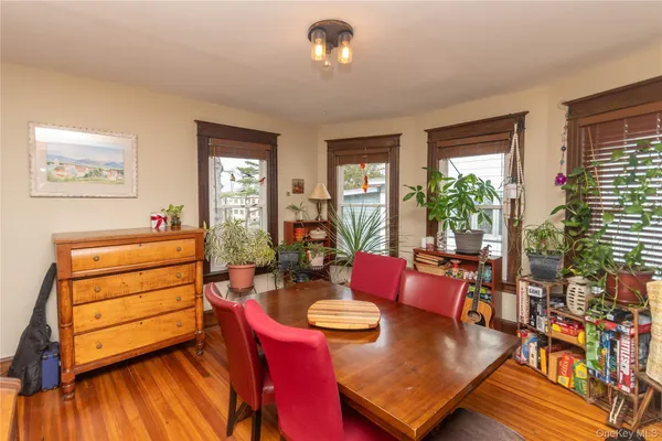 a view of a dining room and livingroom with furniture wooden floor a chandelier