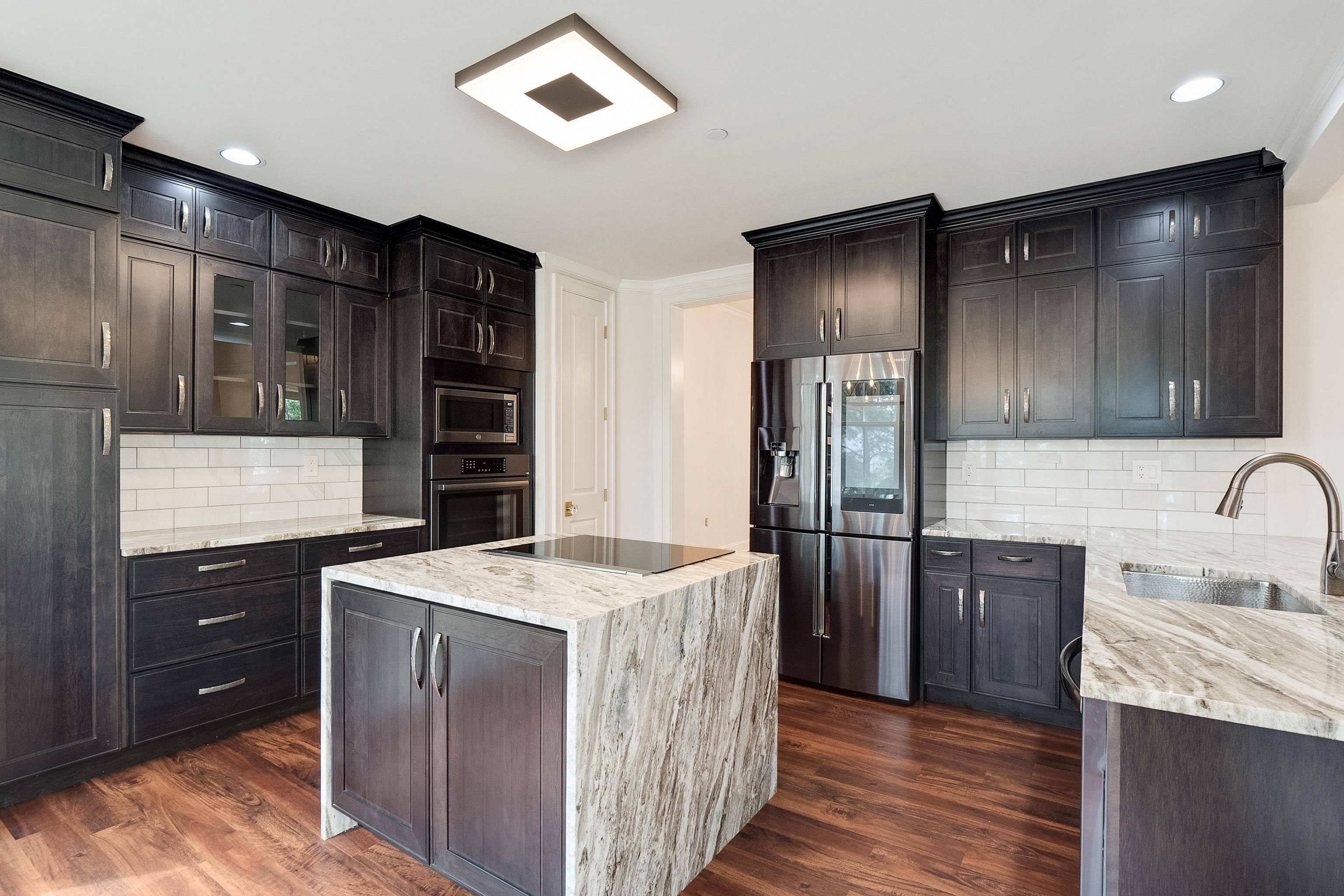 591 Lexington Road, Unit 304R Memphis, TN 38117 - Photo 18 of 35 Complete with new custom cabinets, a hammered stainless farm sink, 'fantasy brown quartzite' counters, and hammered brushed stainless handless.