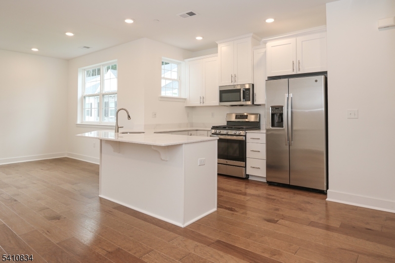 71 Veterans Way Morris Plains, NJ 07950 - Photo 4 of 23 a kitchen with stainless steel appliances granite countertop a sink a stove a refrigerator and island with wooden floor