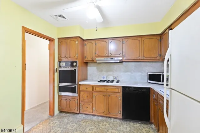 a kitchen with stainless steel appliances granite countertop a stove a sink and a refrigerator