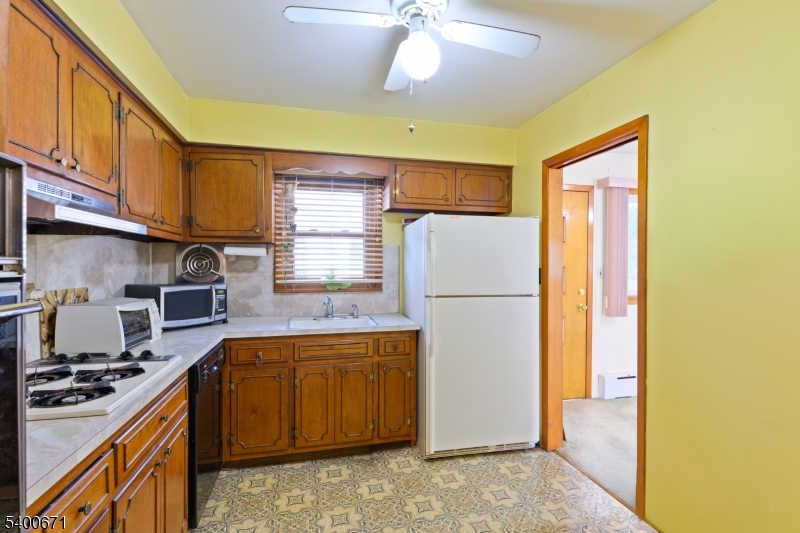 1720 Dewitt Terrace Linden, NJ 07036 - Photo 9 of 29 a kitchen with a refrigerator a stove a sink dishwasher and wooden cabinets