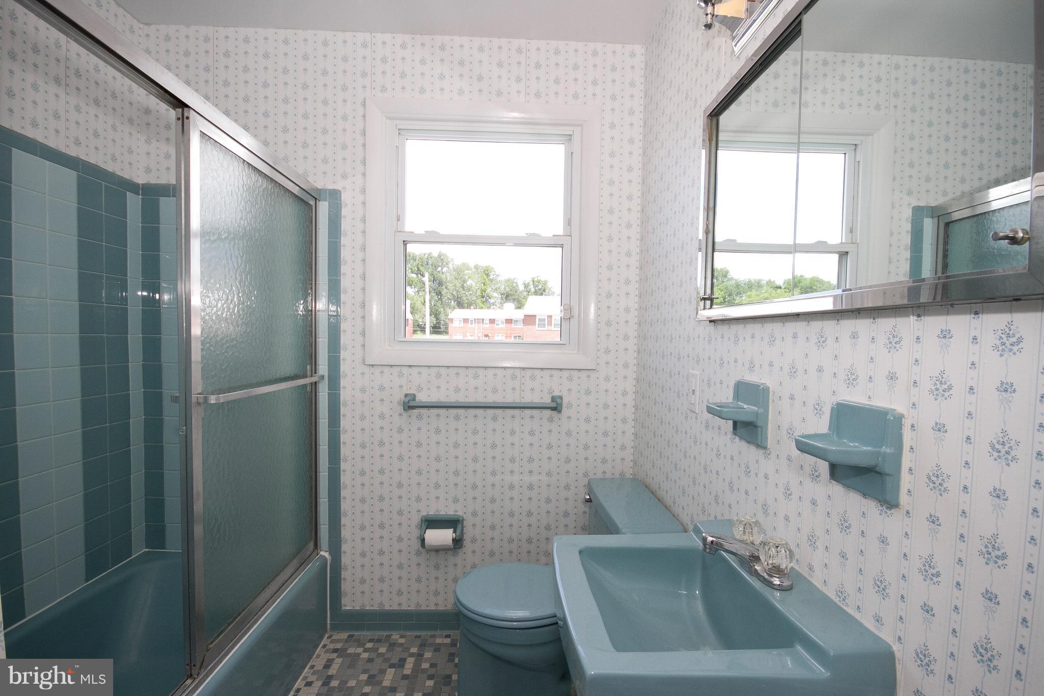 6936 Blanche Road Baltimore, MD 21215 - Photo 13 of 15 a bathroom with a granite countertop toilet a sink a window and mirror