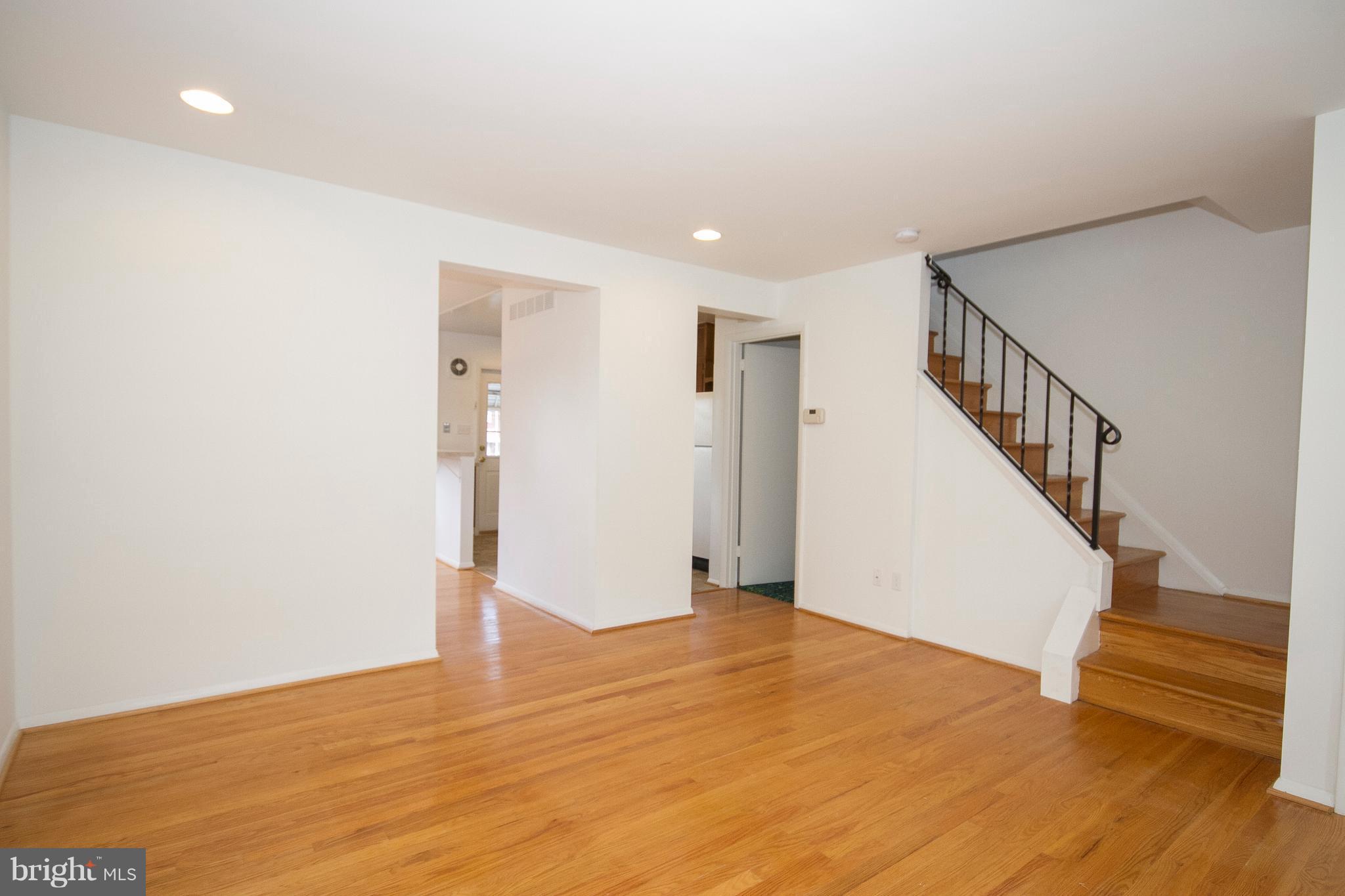 6936 Blanche Road Baltimore, MD 21215 - Photo 5 of 15 a view of an empty room with wooden floor and stairs