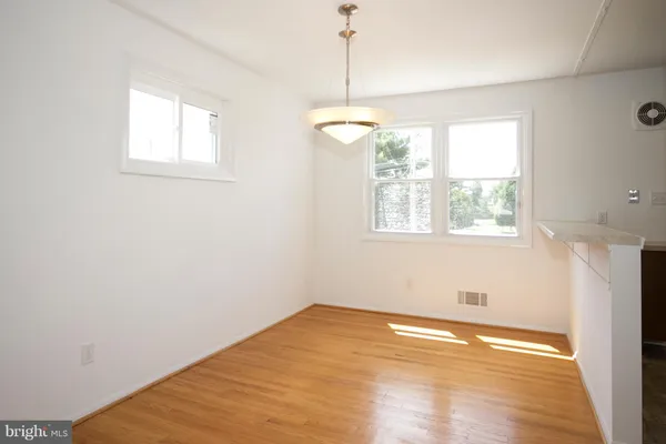 en empty room with wooden floor and windows