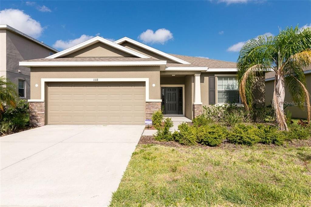 1108 Lauren Manor Loop Ruskin, FL 33570 - Photo 1 of 1 a front view of a house with a yard and garage