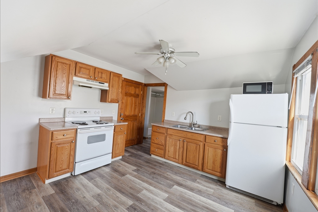 104-106 Madison Street Chicopee, MA 01020 - Photo 18 of 42 a kitchen with a sink a refrigerator and white cabinets