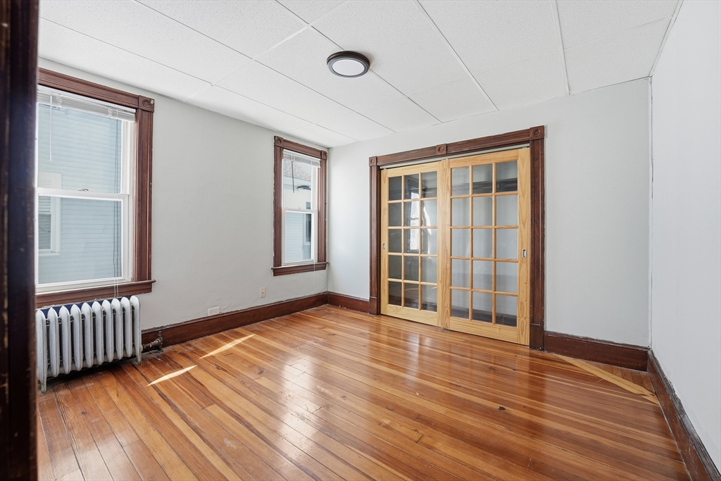 104-106 Madison Street Chicopee, MA 01020 - Photo 22 of 42 a view of an empty room with wooden floor and a window