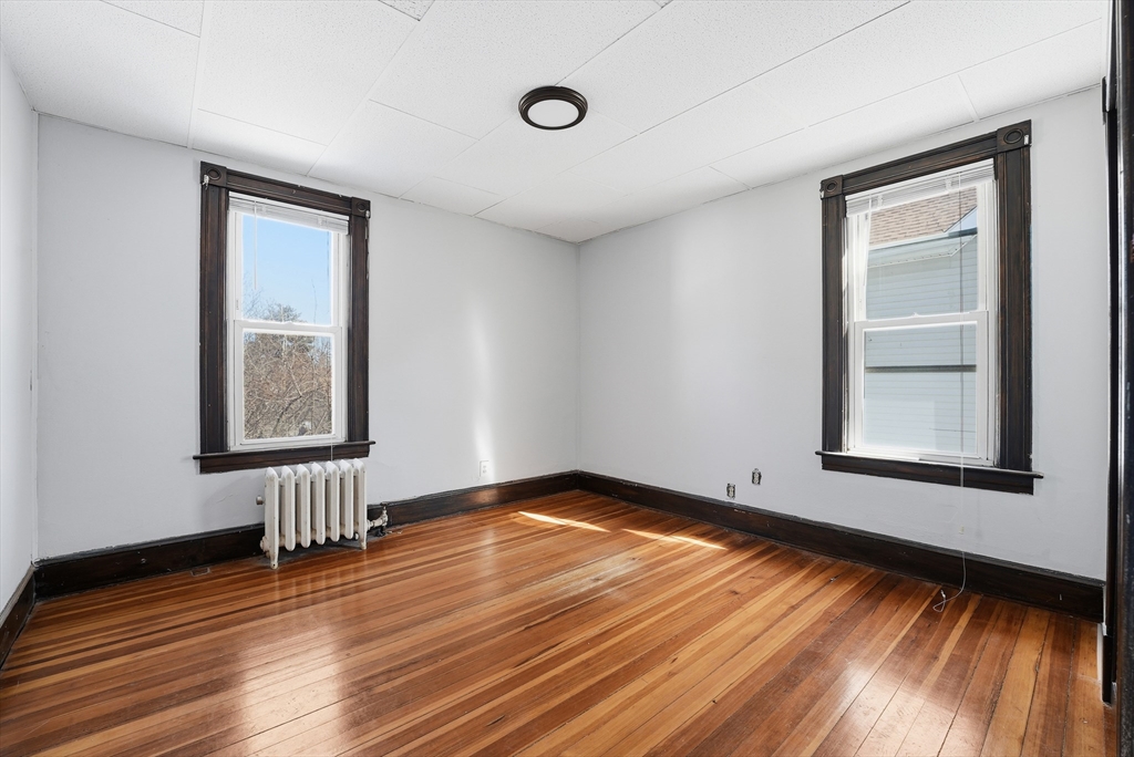 104-106 Madison Street Chicopee, MA 01020 - Photo 25 of 42 a view of an empty room with wooden floor and a window