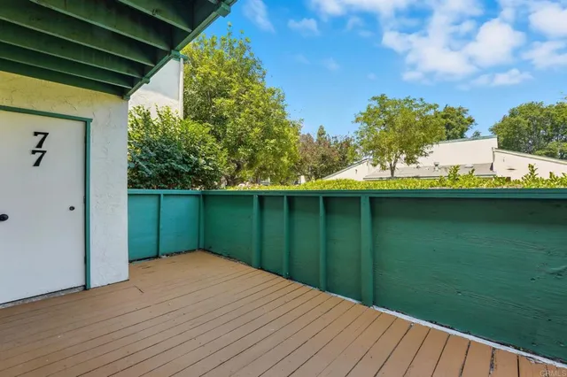 a view of pool with lawn chairs and large trees