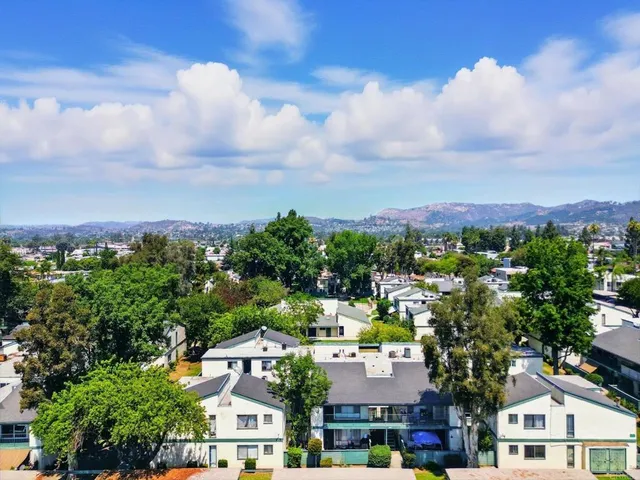 an aerial view of a residential apartment building with a yard and balcony