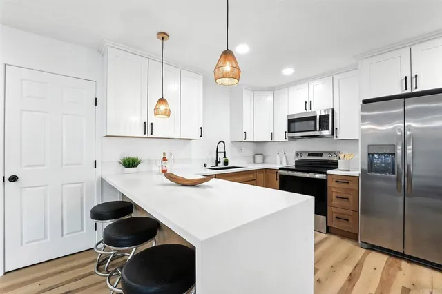 a kitchen with a sink a stove a refrigerator cabinets and a window