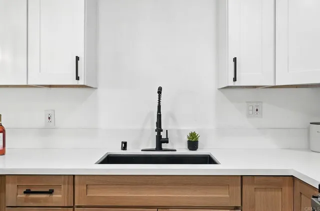 a kitchen with white cabinets and a sink