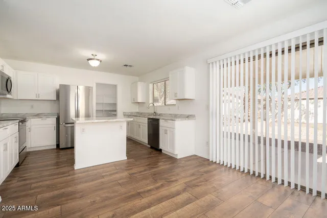 a kitchen with white cabinets and white appliances