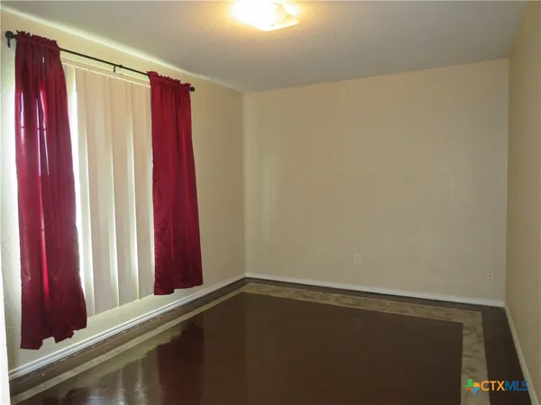a view of a bedroom with red walls and a window