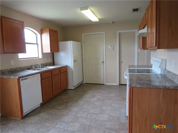 a kitchen that has a sink and a stove in it