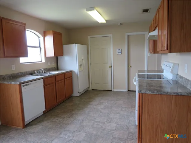 a kitchen that has a sink and a stove in it