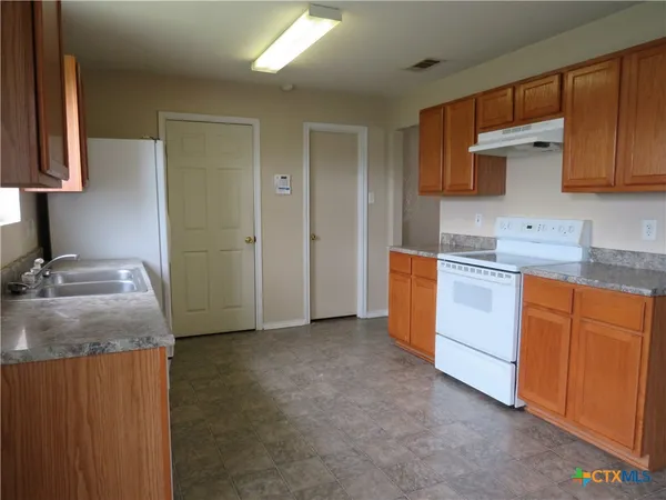 a kitchen with stainless steel appliances granite countertop a sink stove and cabinets